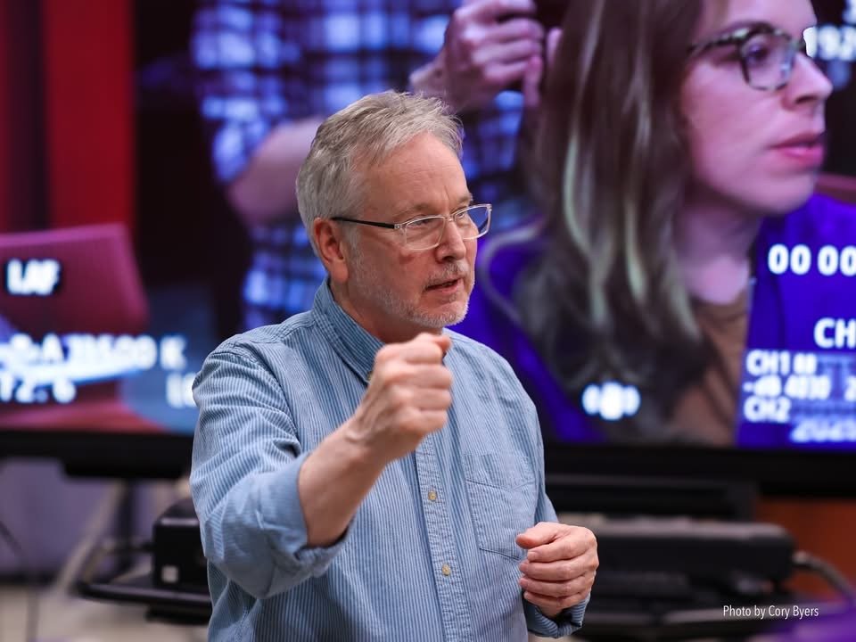 Faculty member directing students in the production control room