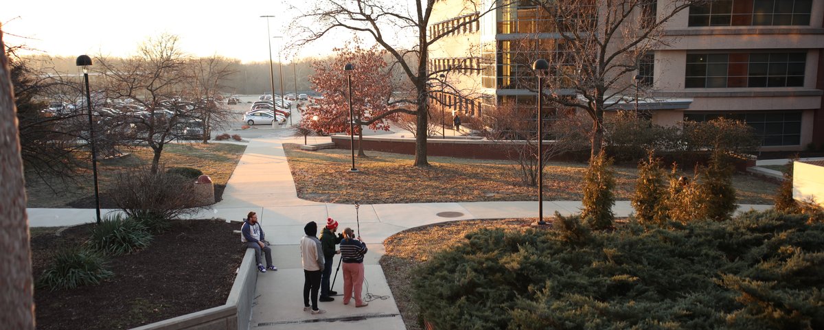 Students filming on location with professional field cameras