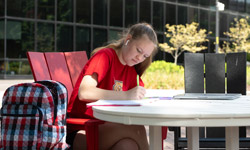 SIUE student working at a table outside.