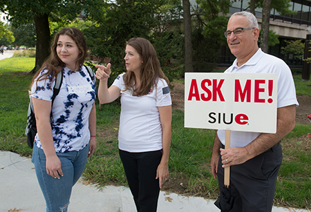 University Housing Director Michael Schultz (right) and Associate Director Mallory Sidarous (middle) offer direction to Heather Winter, of Belleville, on the first day of classes.