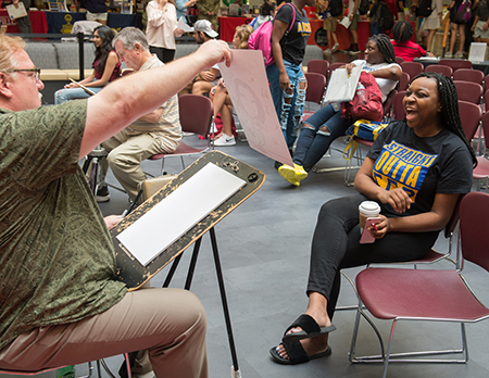 Capri Wroten, of Chicago, reacts happily to her newly created caricature during the SIUE Resource Fair.