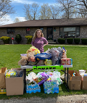 SIUE junior Lexi Reinders stands outside her house with donated items to be used for sack lunches.