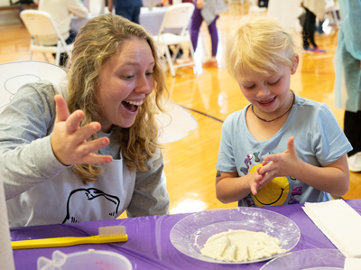 An SIU SDM dental student interacts with a child at one of the Give Kids a Smile Day Smile Stations. 