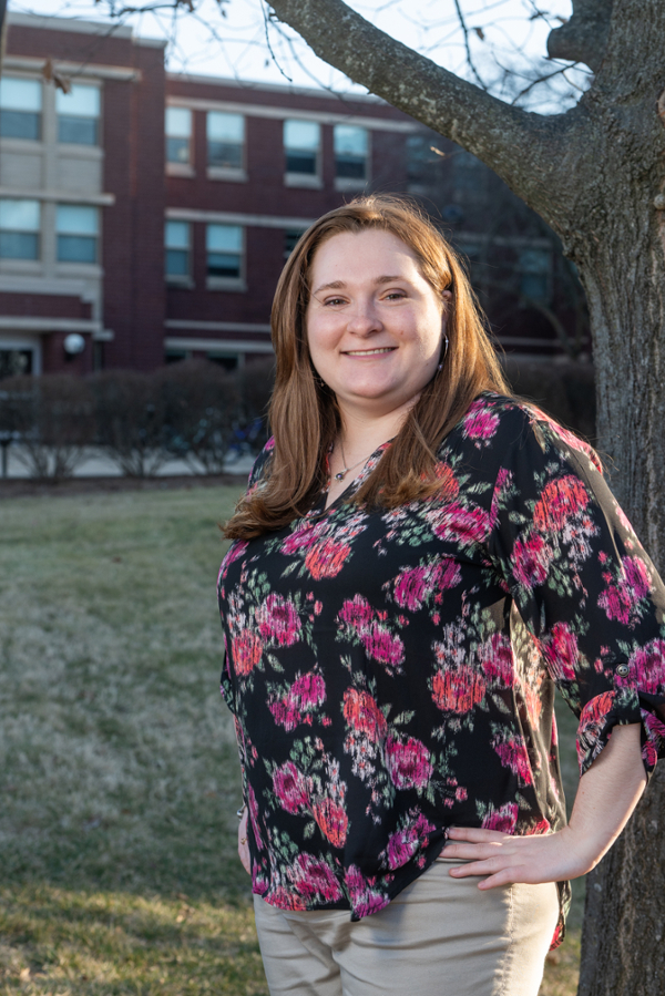 Portrait of Maddy Walter outside a residence hall on a sunny spring afternoon