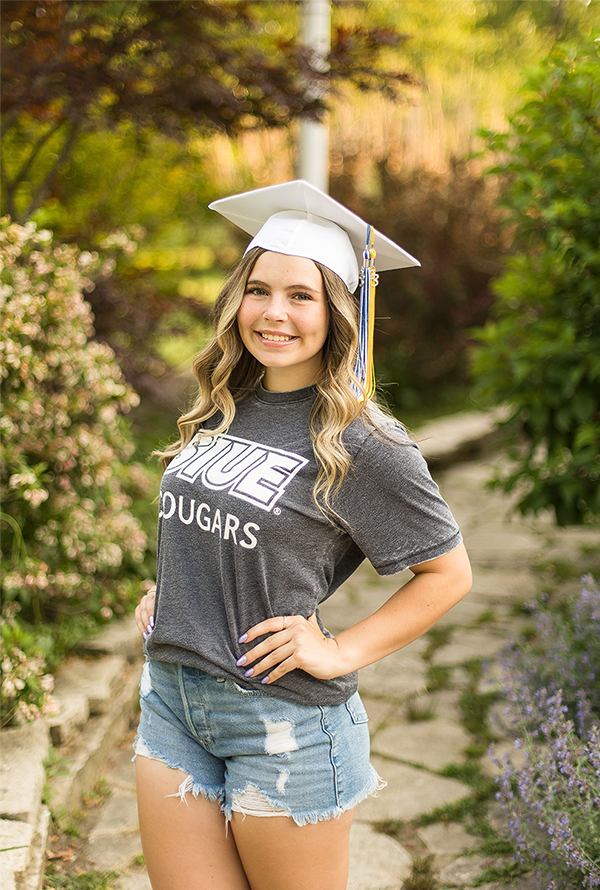 Photo of Anna Schleyhan outside in graduation cap