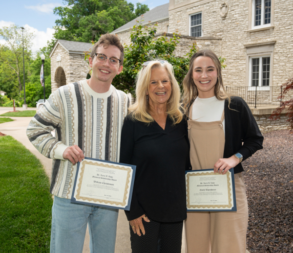 SIU SDM third year students Christensen and Thornberry with their team member and holding their awards