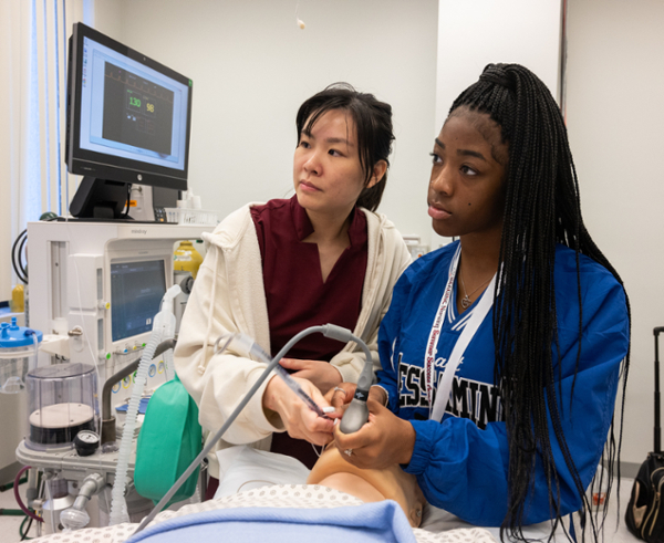 Nurse and student work together at administering care