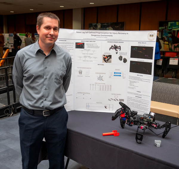 Ryan Cafarelli stands in front of his award winning project displayed as poster presentation