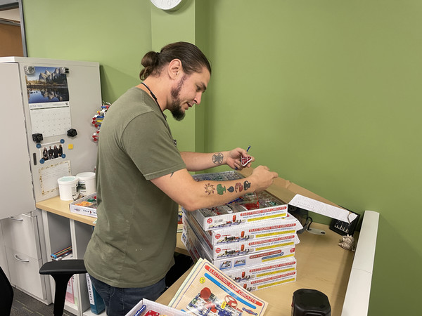 Dean Crosby working with a stack of circuit games