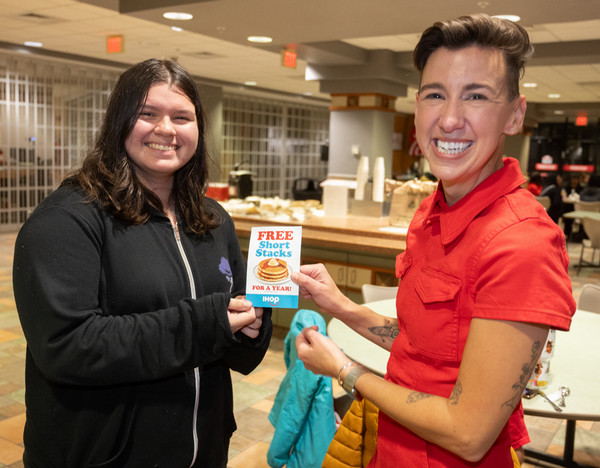 Two people holding sign with prize