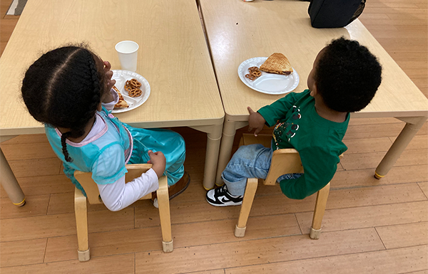 Back of two children seated at childs table