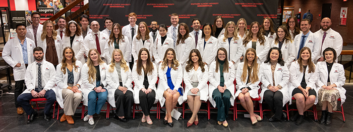 group shot of Nurse Anesthesia Program 10th anniversary cohort in their white coat ceremony in the Goshen Lounge