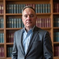 portrait of Benoit in a suit in a library like room