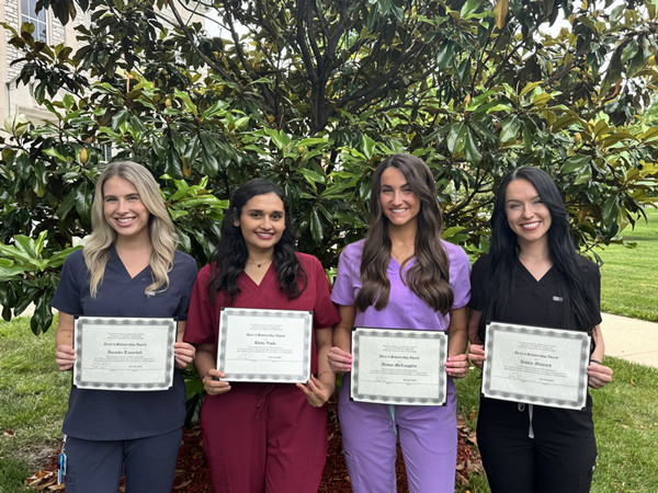 Four scholarship winners hold awards