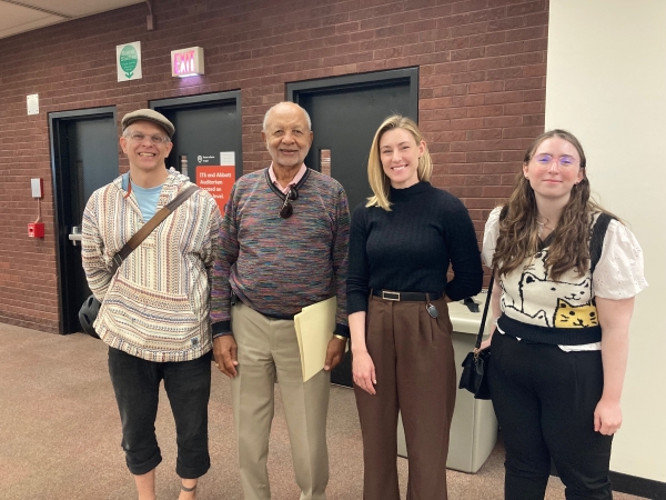 Marcella with two LIS faculty members and alumnus Al Johnson posing for a photo in the Lovejoy Library in front on the doors to the straircase.