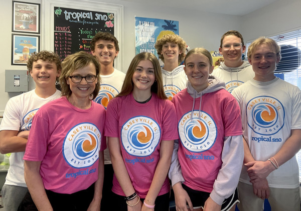 Work crew and family at sno cone establishment with some wearing the company tee