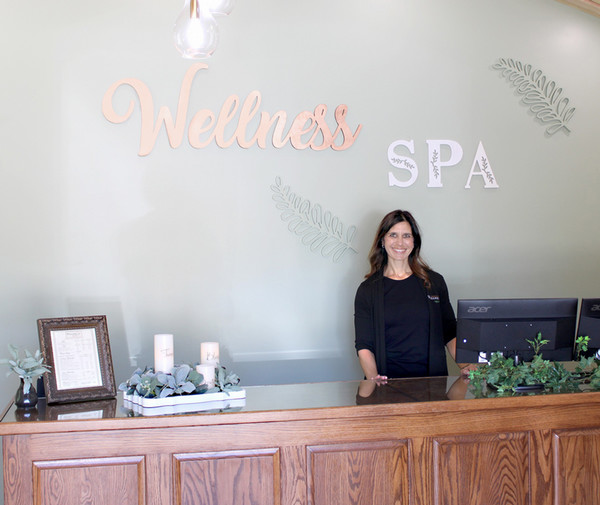 Heather Greenwood standing at reception desk under her brand logo