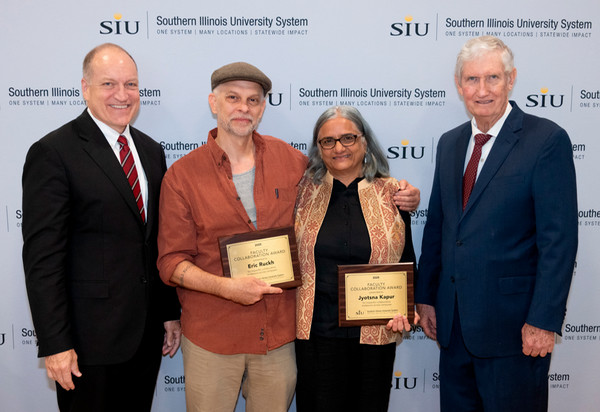 Photo of Mahony, Ruckh, Kapur and Gilbert standing with plaques