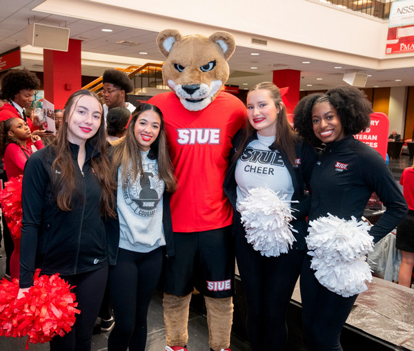 Students pose with pom poms and Eddie the Cougar