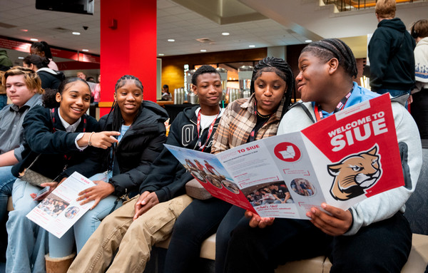 Students seated and reading SIUE pamphlet