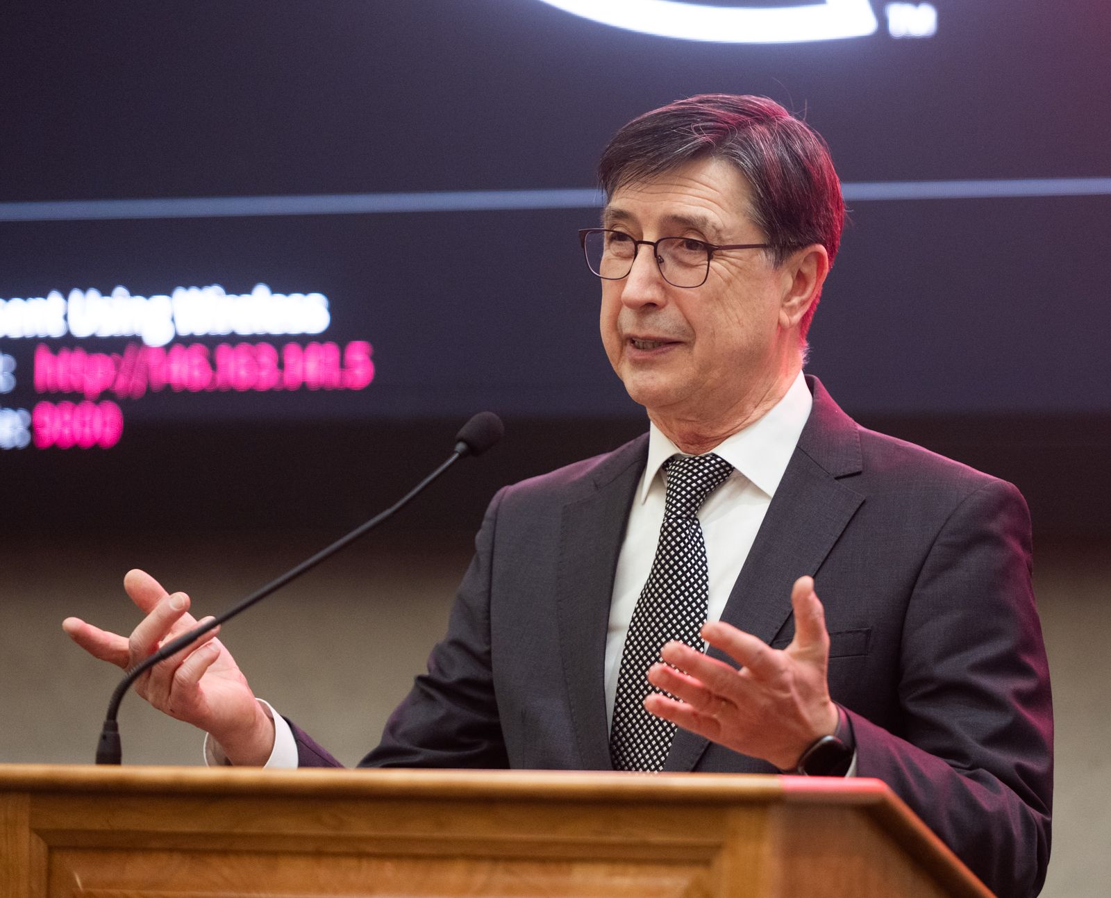 Photo of Dean Karacal speaking at a podium inside the Engineering atrium
