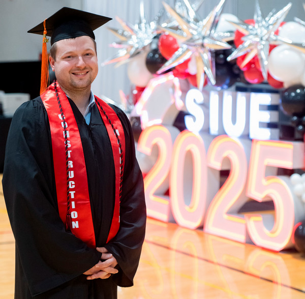 Graduate Hunter Mantz in front of commencement light display