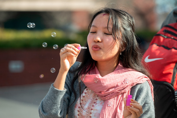 A student blows bubbles on the cloud on a sunny day