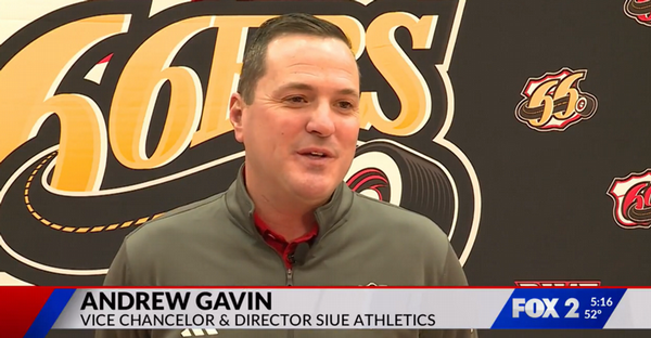 Andrew Gavin, vice chancellor and director of SIUE Athletics, speaks during a televised interview in front of a SIUE 66ers backdrop.