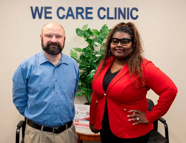 State Rep. Schmidt and Dr. Myjal Garner are standing in front of the WE CARE Clinic