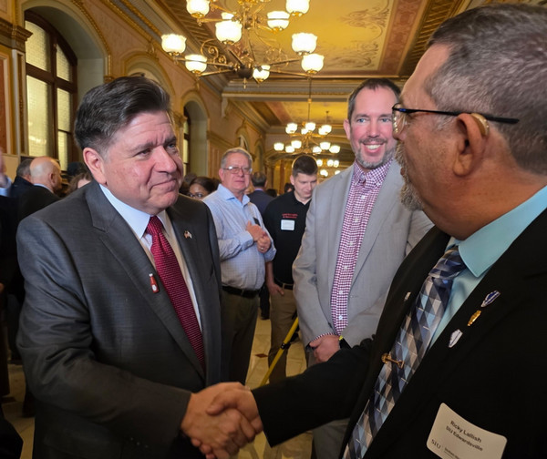 Gov. Pritzker shakes hands with Ricky Lallish, Director of the ERTC in the rotunda of the Illinois Capitol building.