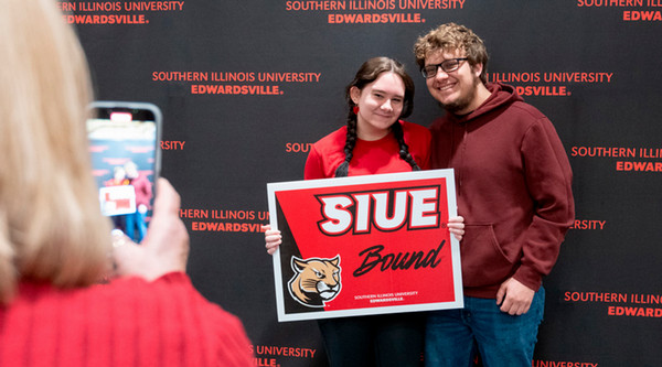 Students holding SIUE admitted sign
