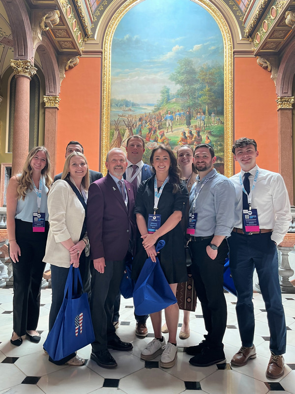 Group of students and alumni posing at the capitol