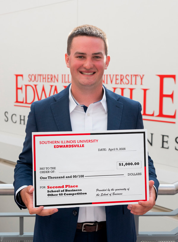 Student Tyler Robertson holds his second place award and faces camera