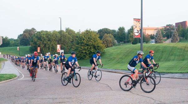 A group of cyclists leave SIUE campus and turn a corner