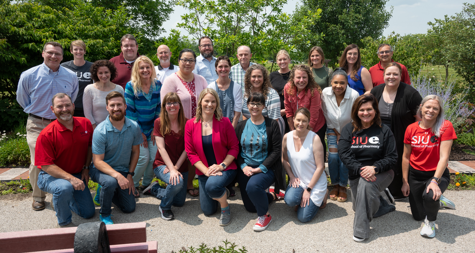 Faculty and staff happily posing outside for a photo 