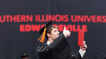 SIUE student giving a thumbs up at commencement.