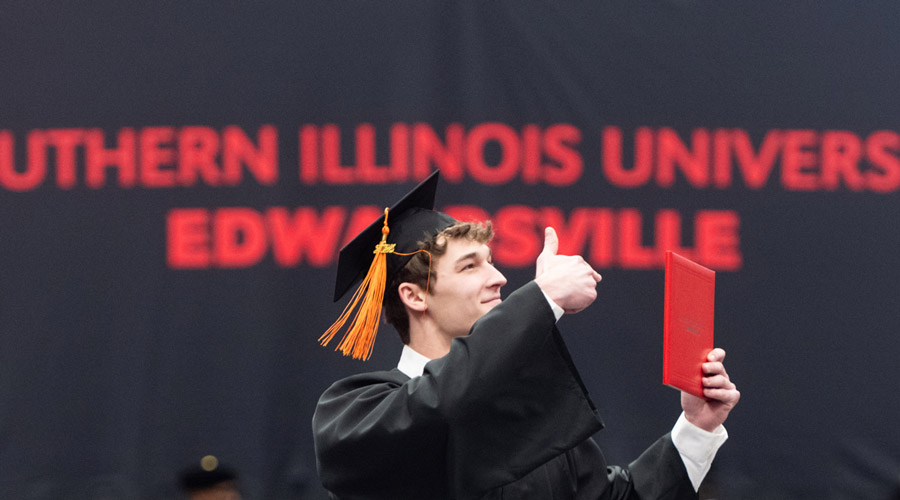 SIUE student giving a thumbs up at commencement.