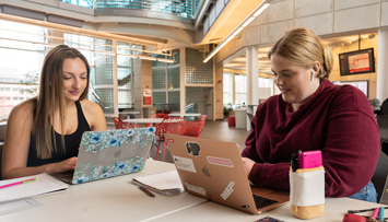 Three SIUE students working around a computer.